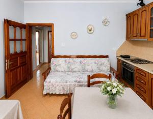 a kitchen and living room with a table and a couch at Garden Oasis in Vlore in Vlorë