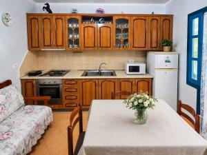 a kitchen with a table with a vase of flowers on it at Garden Oasis in Vlore in Vlorë