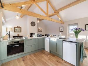 a large kitchen with blue cabinets and wooden beams at 1 Bed in Carnforth oc-90554 in Middleton