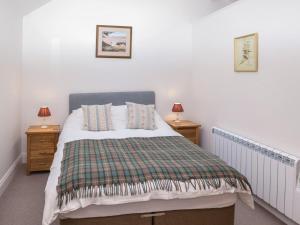 a bedroom with a bed with two night stands and two lamps at 1 Bed in Carnforth oc-90554 in Middleton
