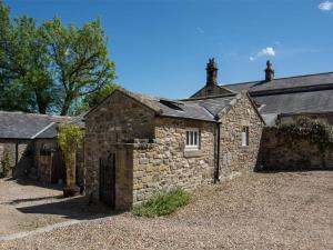 an old stone building with a gate in a yard at 1 Bed in Riding Mill oc-cn063 in Corbridge