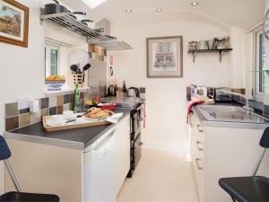 a kitchen with white cabinets and black counter tops at 1 Bed in Riding Mill oc-cn063 in Corbridge