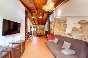a living room with a couch and a tv at El Cau dels Somnis in La Cuevarruz