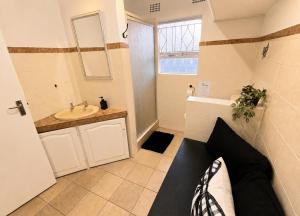 a bathroom with a sink and a toilet and a mirror at Zhantique Guest House 2- Unit 11 in Boksburg +8 photos
