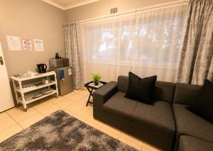 a living room with a couch and a window at Zhantique Guest House 2- Unit 11 in Boksburg