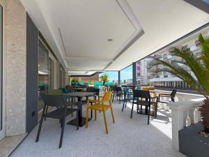a restaurant with tables and chairs and a balcony at Hotel Universal in Caorle