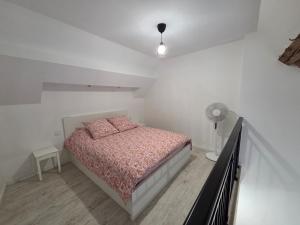 a white bedroom with a bed and a lamp at Nuit douce au LYS in Phalsbourg