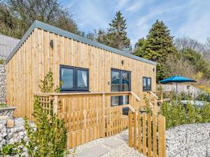a wooden house with a fence and an umbrella at 1 Bed in Weymouth oc-82099 in Osmington
