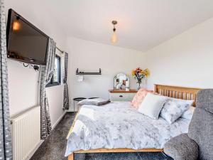 a bedroom with a bed and a flat screen tv at 1 Bed in Weymouth oc-82099 in Osmington