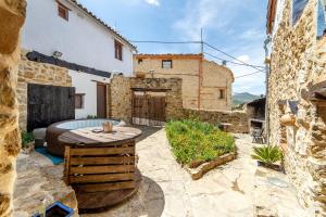 a patio with a wooden table and a building at El Cau dels Somnis in La Cuevarruz