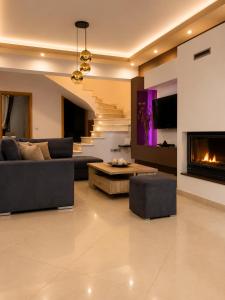 a living room with a couch and a fireplace at Villa Rose Ground Floor - Private Swimming Pool Garden in Koskinou