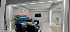 a living room with a blue couch and a table at Promenade Apartment ,Sea view in Durrës