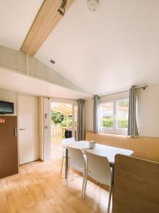 a kitchen and dining room with a table and chairs at Camping calme En Charente Maritime in Surgères