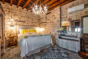 a bedroom with a large bed in a brick wall at George & Alexandra's Apartments in Rhodes Town