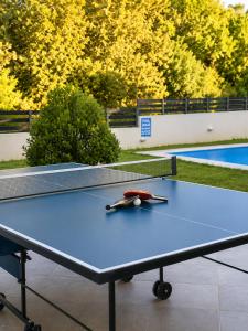 a ping pong table with a pair of scissors on it at Villa Rose Ground Floor - Private Swimming Pool Garden in Koskinou