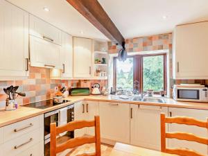 a kitchen with white cabinets and a sink and a window at 2 Bed in Skipton oc-92898 in Airton +7 photos