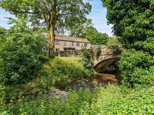 an old stone house with a bridge over a stream at 2 Bed in Skipton oc-92898 in Airton