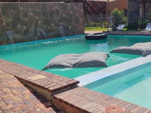 a swimming pool with a waterfall in a yard at Myoli Beach Breeze in Sedgefield