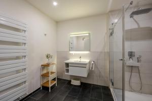 a white bathroom with a sink and a shower at Strandhaus Zingst Apartment 11 in Zingst +23 photos