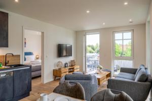 a living room with two couches and a kitchen at Strandhaus Zingst Apartment 11 in Zingst
