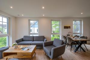 a living room with a couch and chairs and a table at Strandhaus Zingst Apartment 11 in Zingst