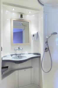 a bathroom with a sink and a mirror at CLASSIC HÔTEL Reims Est - Taissy in Reims +20 photos