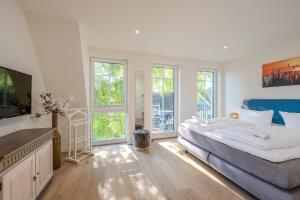 a bedroom with a large bed and a television at Strandhaus Zingst Apartment 16 in Zingst