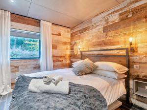 a bedroom with a bed with a wooden wall at 2 Bed in Lymington oc-95021 in Brockenhurst