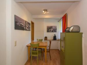 uma sala de jantar com uma mesa e um frigorífico verde em Altstadt Ferienwohnung Guade Zeit em Füssen