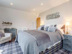a bedroom with a large bed and a chair at 2 Bed in Lairg oc-86104 in Durness