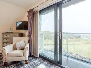 a room with a chair and a large window at 2 Bed in Lairg oc-86104 in Durness