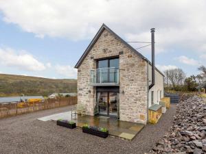 a stone house with a balcony on the side of it at 2 Bed in Lairg oc-86104 in Durness