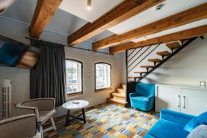 ein Wohnzimmer mit blauem Sofa und Treppe in der Unterkunft Hotel Bulwar Ustka in Ustka