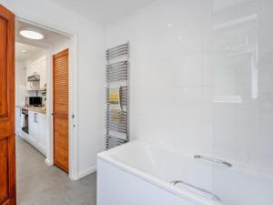 a white bathroom with a tub and a kitchen at 2 Bed in Freshwater oc-91606 in Freshwater +17 photos