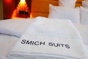 a white blanket with the wordsswitch switches on a bed at Smich Suites in Abuja