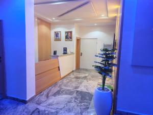 a hallway with a blue vase with a plant in it at Smich Suites in Abuja