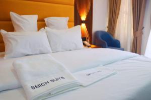 a white bed with two white towels on it at Smich Suites in Abuja