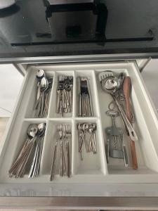 a drawer filled with utensils in a refrigerator at Apartamento B T4 Pombal in Pombal