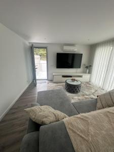 a living room with a couch and a flat screen tv at Apartamento B T4 Pombal in Pombal