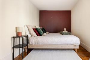 a bedroom with a bed with a brown wall at Le 120 Amiens in Amiens