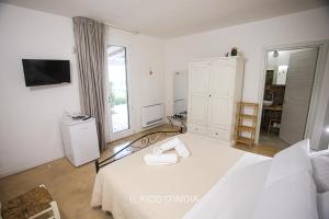 a white bedroom with a bed and a window at B&b Casina Il Mandorlo in Nardò