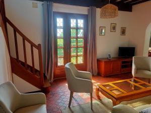 a living room with a couch and chairs and a tv at Au cerisier in Saint-Maulvis