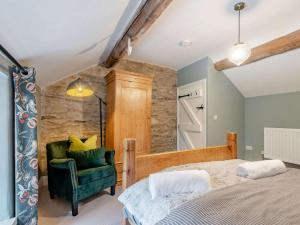 a bedroom with a bed and a green chair at 2 Bed in Hope Valley oc-88979 in Sheffield