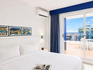 a bedroom with a white bed and a large window at Hotel Las Vegas in Calella +21 photos