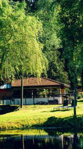 a bench sitting in front of a building next to a lake at Gacka idila 2 in Otočac