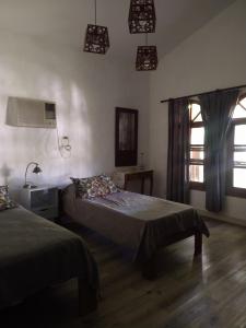 a bedroom with two beds and a window and lights at Monoambiente KALKI in Roldán