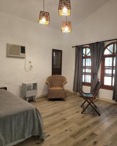 a bedroom with a bed and a chair and windows at Monoambiente KALKI in Roldán