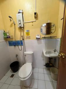 a small bathroom with a toilet and a sink at MG 5pax 1 AC BR 300mbps FREE Netflix Parking Cignal Videoke Shower Heater Cook & Grill in Rodriguez +24 photos