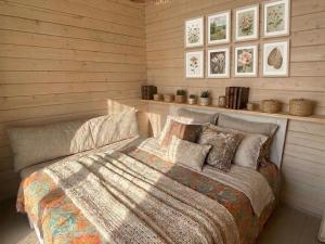 a bedroom with a bed in a room with wooden walls at Ezermāja "Spārītes" in Geraņimova