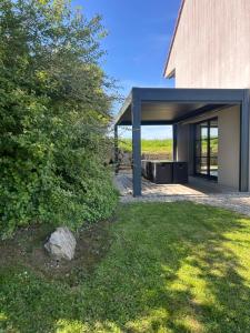 a modern house with a garage and a tree at Le jardin de la mer in Wierre-Effroy